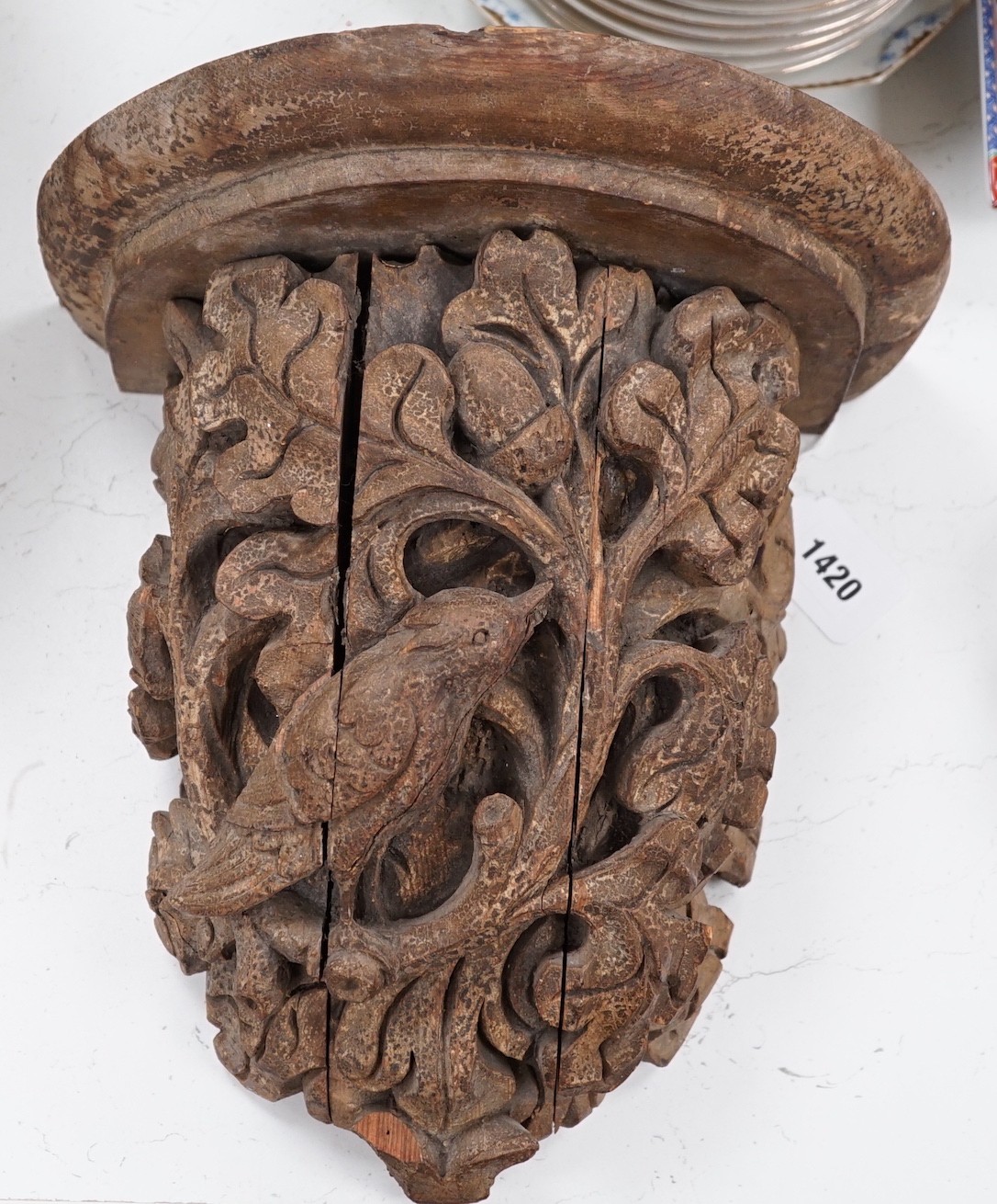 A Victorian/Edwardian carved pine wall bracket, carved with a bird within scrolling oak leaves, 36cms high